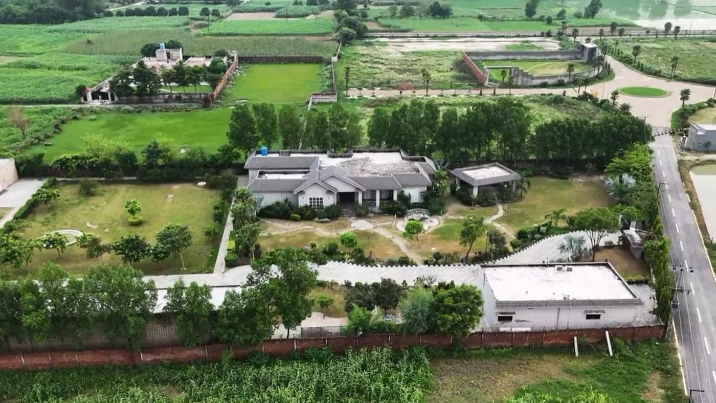 Aerial view of a Flaura Farms style farmhouse estate set among open lawns